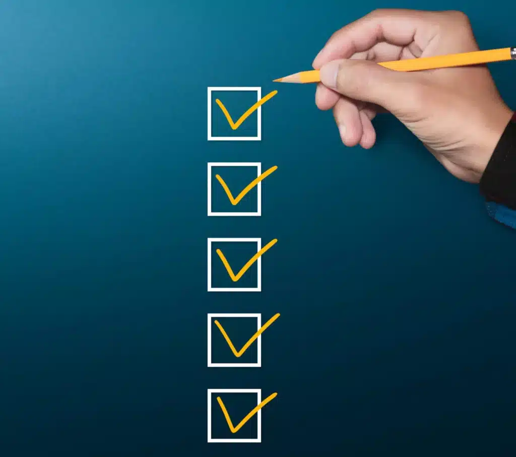 A person writing a checklist on a blue background.