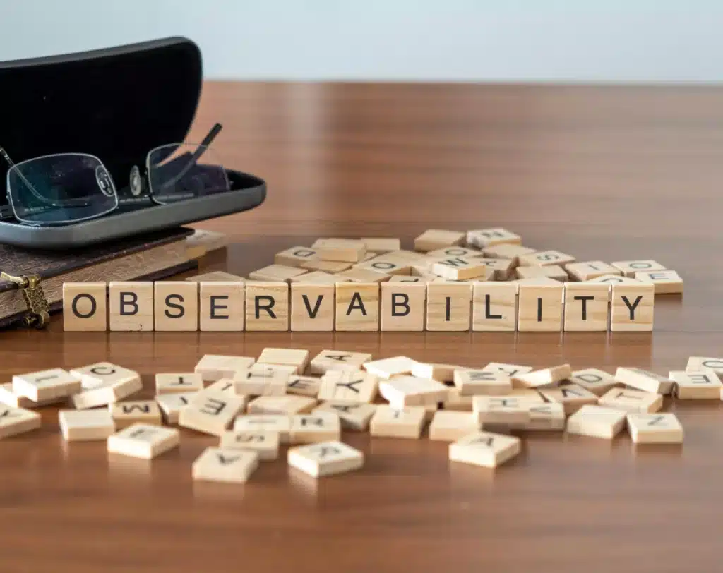 A wooden scrabble board with the word observerability on it.