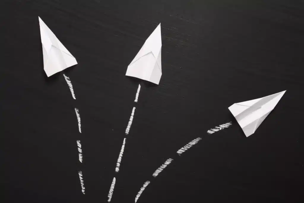 Three paper arrows are drawn on a blackboard.
