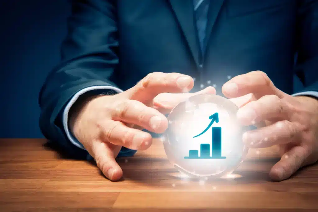 A businessman's hands holding a crystal ball with a growth chart on it.