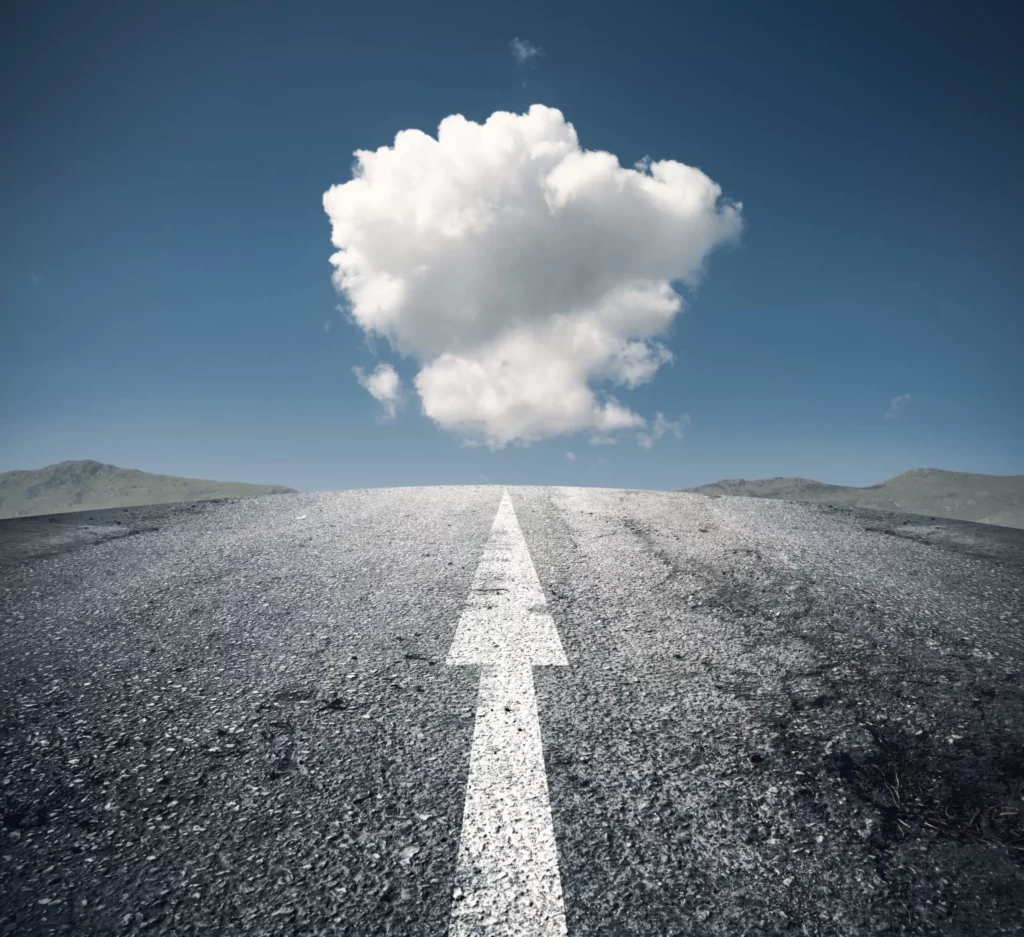 An empty road with a cloud in the sky.