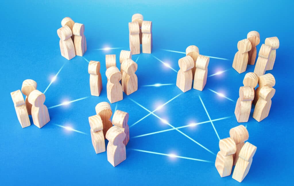 A network of cloud native observability players formed by wooden people against a blue background.