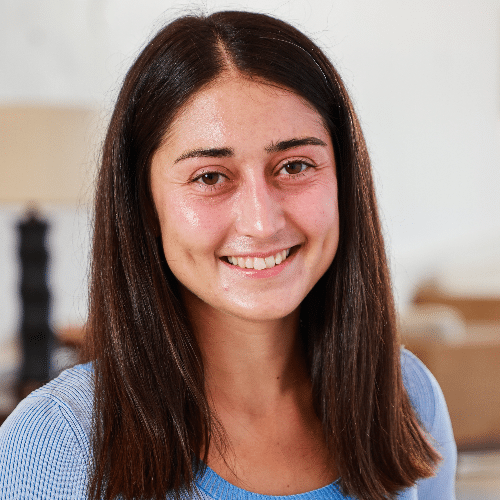 A smiling young woman in a blue shirt.