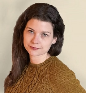 A woman in a brown sweater posing for a photo.