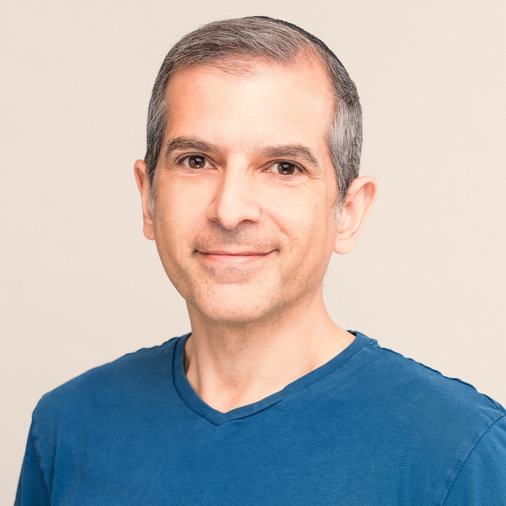 A man in a blue shirt is smiling at a cloud native application.