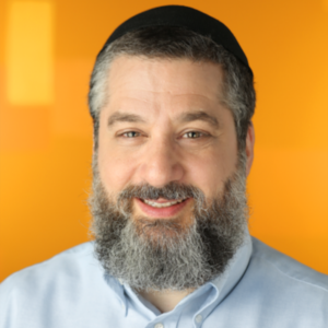 Man with a gray beard, wearing a black head covering and light blue shirt, smiles in front of an orange background. Catch his insights on Off-Call with Paige Cruz, Podcast Ep 1-3.